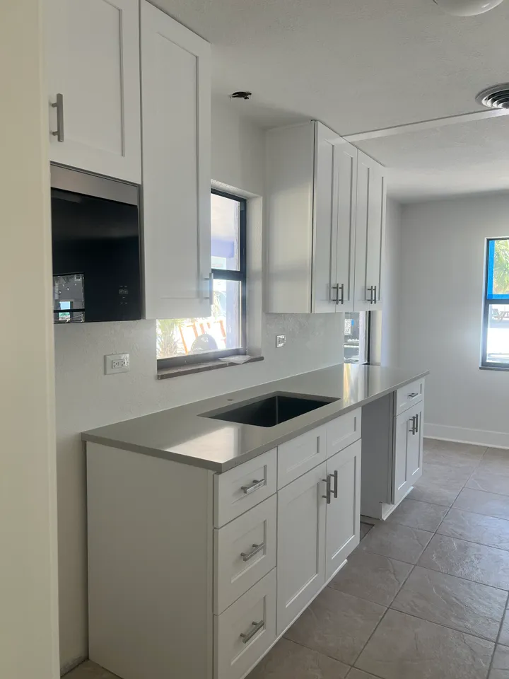 Kitchen renovation with white cabinetry completed by Smirnov Construction